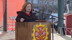 Nainen puhuu pöntössä, jossa on SDP:n logo.