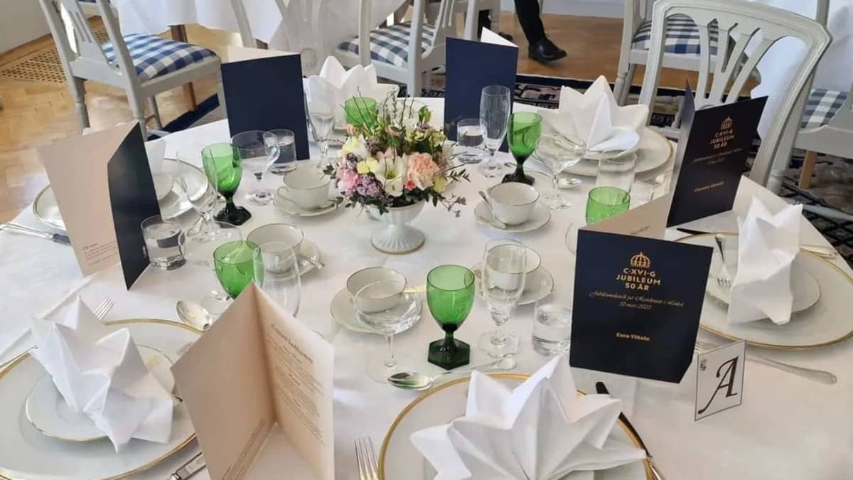 Ruotsin kuninkaan juhlalounaan pöytä, jossa kaunis vihreä-valkoinen kattaus.