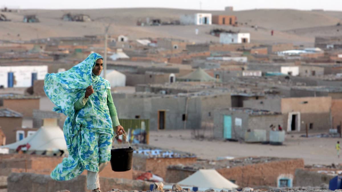Sahrawin kansaan kuuluva nainen kantaa ämpäriä pakolaisleirissä Algerian puoellla