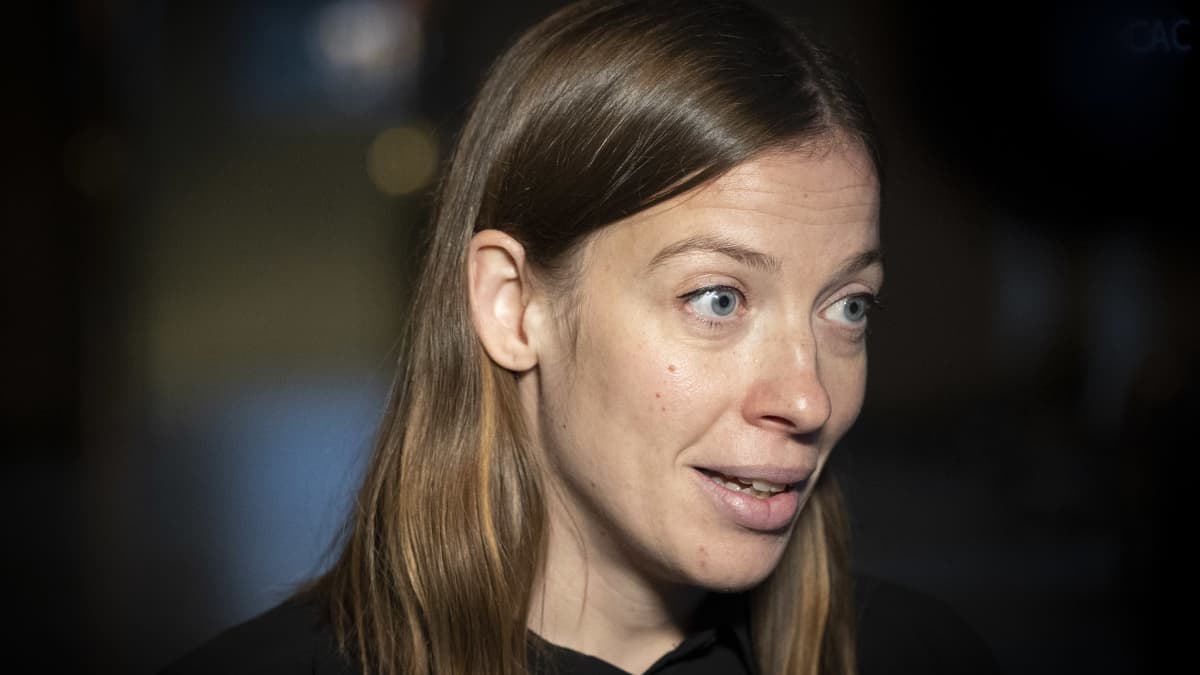 Opetusministeri Li Andersson kävelee Ylen haastattelussa Eduskunnan Valtiosalissa。