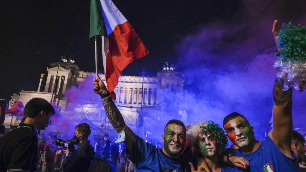 Kolme Italian kannattajaa heiluttaa Italian lippua, kasvot maalattu viher-puna-valkoisiksi