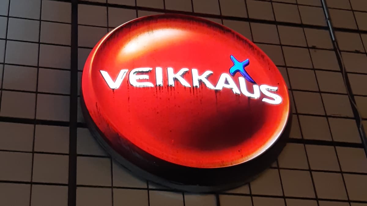 En upplyst Veikkaus-logo på en husvägg