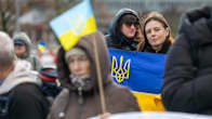 Mielenosoittajia kädessään Ukrainan lippuja.