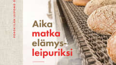 Kirjan Aikamatka elämysleipuriksi kansikuva, jossa kirja nimi ja ruisleipiä jonossa. 