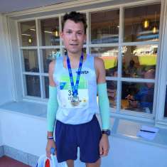 Leonid Latsepov stands with a medal after finishing the half marathon. 