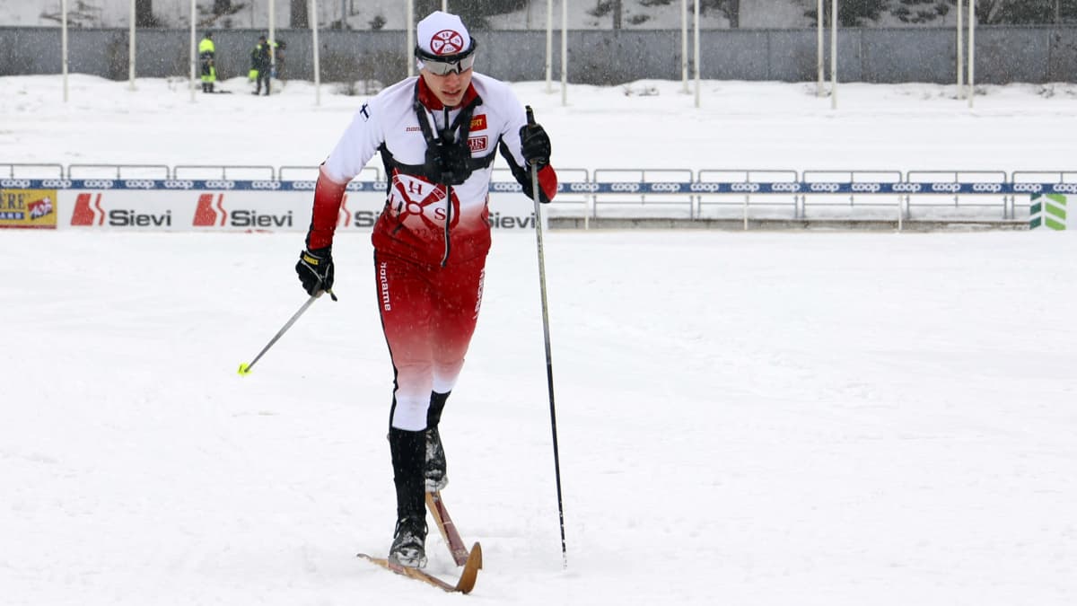 Lahden hiihtoseuran Onni Mäiselin kokeilee vanhoja Järvisen puusuksia Lahden hiihtostadionilla.