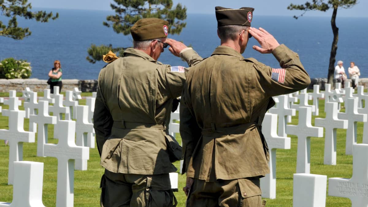Amerikanska soldater står på en gravgård för offren på Normandie.