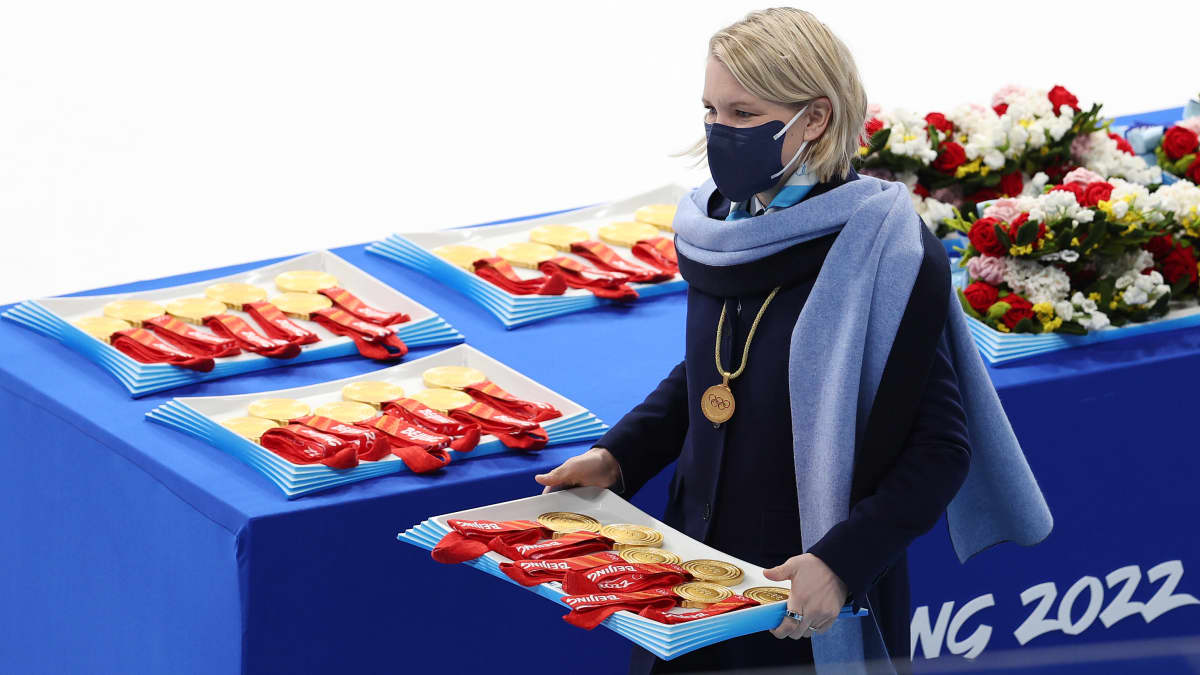 Emma Terho jakamassa mitaleita Pekingin olympialaisten naisten jääkiekkofinaalin jälkeen.