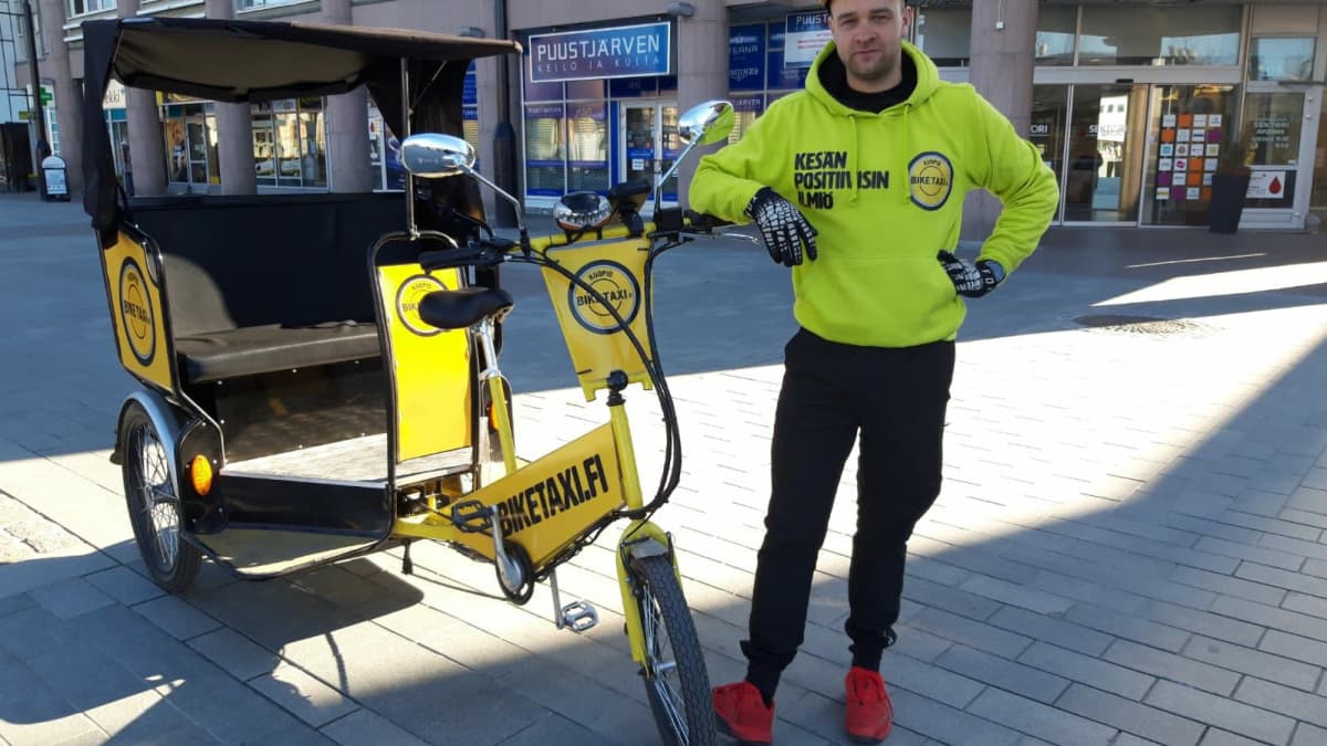 Biketaxin yrittäjä Miika Keihänen polkupyörätaksinsa vieressä Kuopion keskustassa.