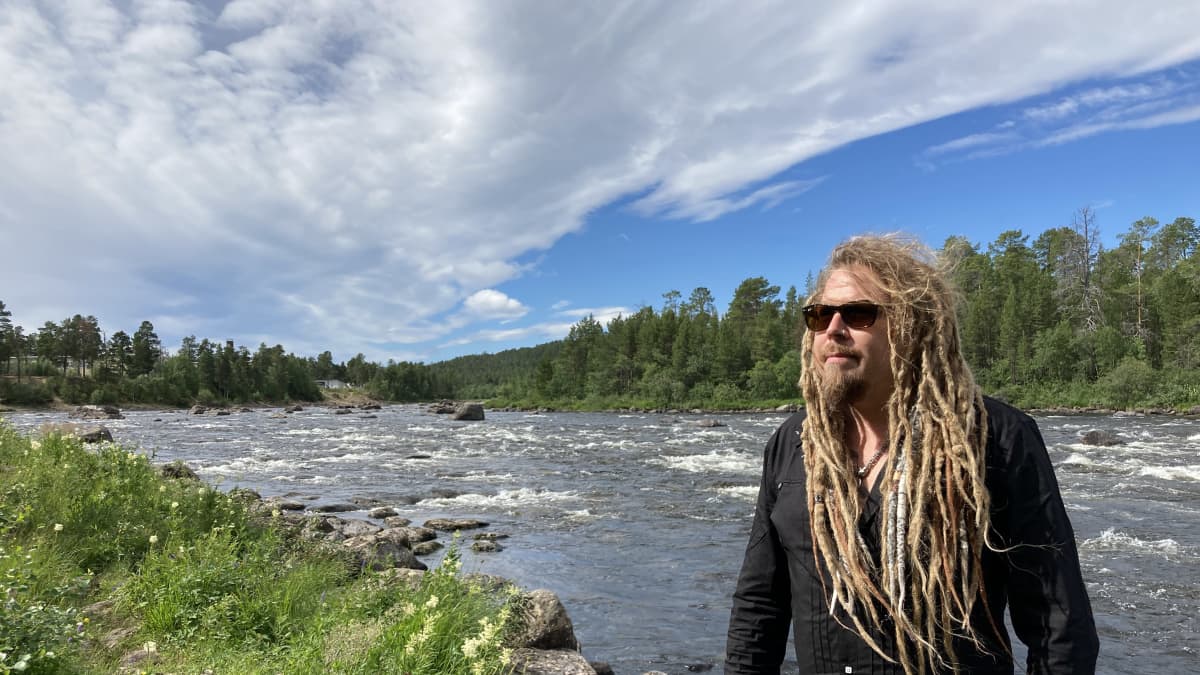 Muusikko Jonne Järvelä seisoo Juutuanjoen rannalla.