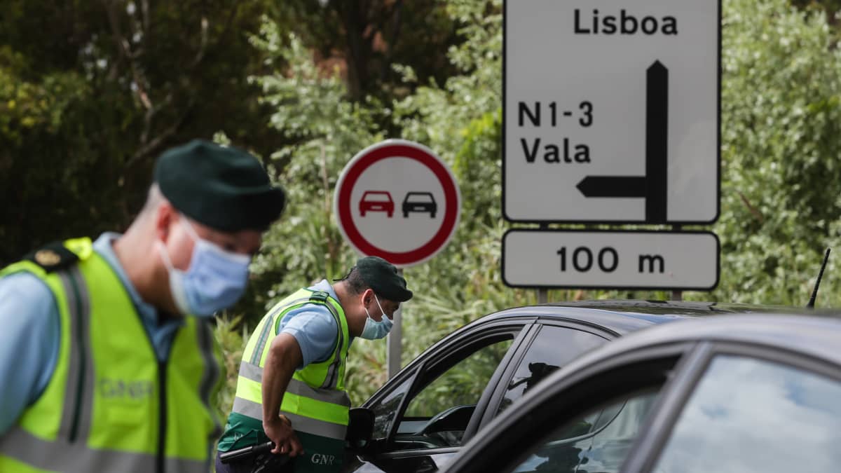 Maskipäiset poliisit valvomassa Lissabonista poistuvaa liikennettä koronarajoitusten vuoksi.