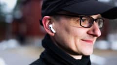 Leo Stranius lähikuvassa ulkona kerrostalojen pihalla. Korvissa hänellä on pienet langattomat kuulokkeet.