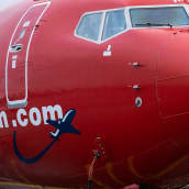 yleiskuva - Norwegian -halpalentoyhtiön kone lentokentällä odottamassa matkustajia. Lähikuva koneen keulasta.