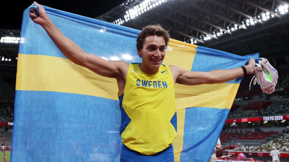 Armand Duplantis håller upp den svenska flaggan.