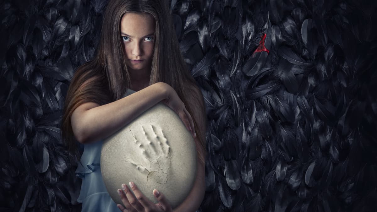 Tyttö pitää sylissään isoa linnunmunaa, jonka pinnassa näkyy käden painauma. Hanna Bergholmin valmisteilla olevan Pahanhautoja-kauhuelokuvan ennakkomateriaalia. 