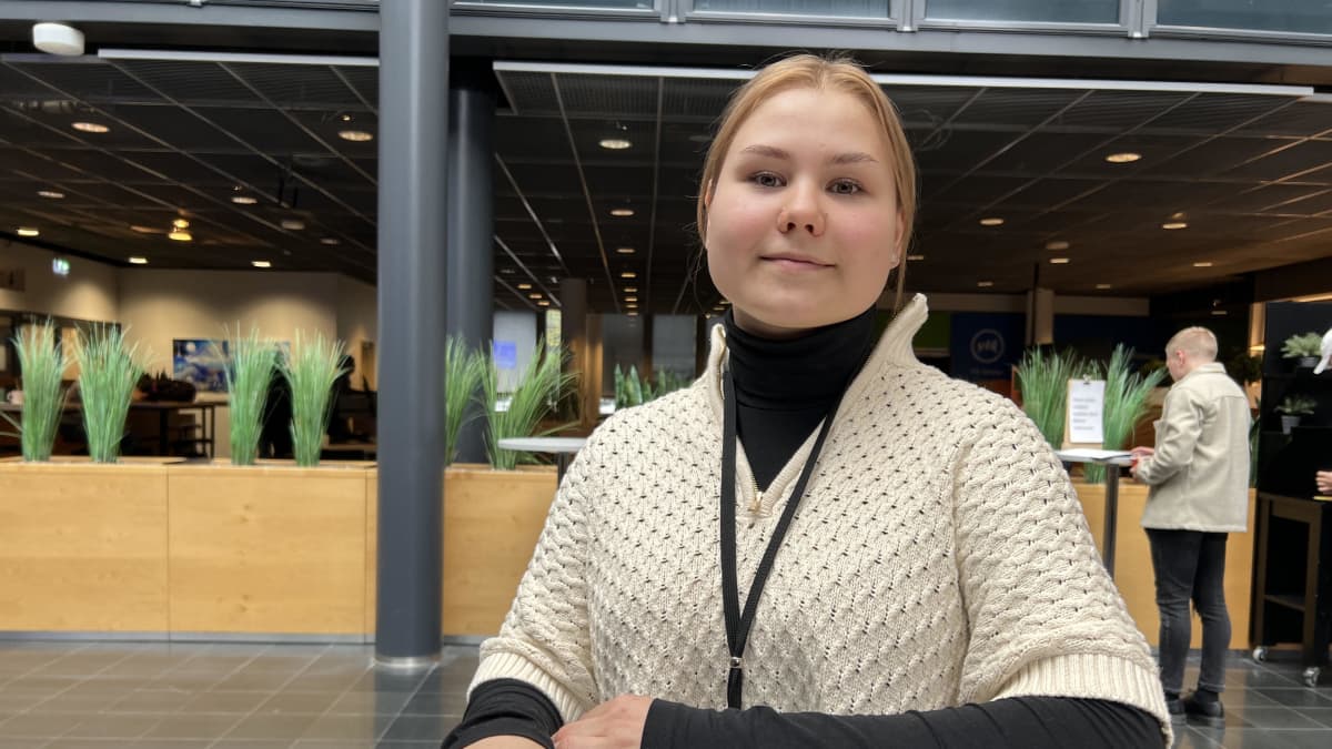 Tradenomiksi opiskeleva Ilona Hirvonen seisoo opiskelupaikkansa Haaga-Helian aulassa.