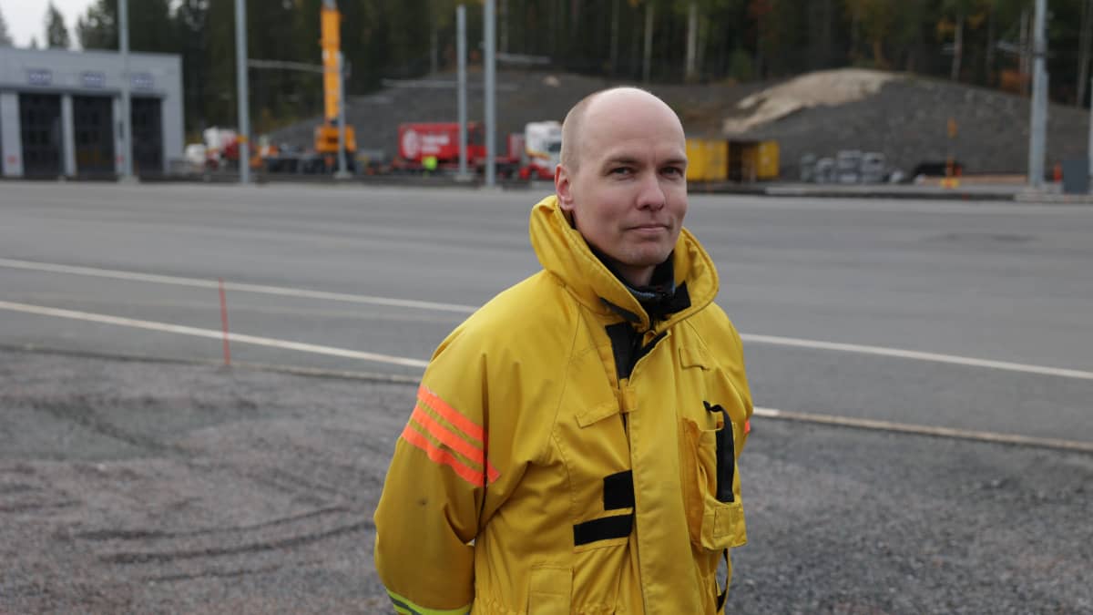 Palomestari Antti Koskela seisoo Tampereen Raitiotien varikon pihalla, päällä keltainen univormu.