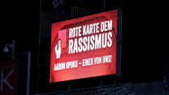 Valotaululla lukee saksaksi: Punainen kortti rasismia vastaan, Aaron Opoku - yksi meistä!