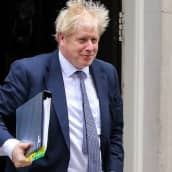 Britannian pääministeri Boris Johnson poistuu työasunnoltaan parlamentin kyselytunnille 23. lokakuuta 2019. Johnsonilla on kädessään kansio, jossa on useita eri värikoodilappuja.
