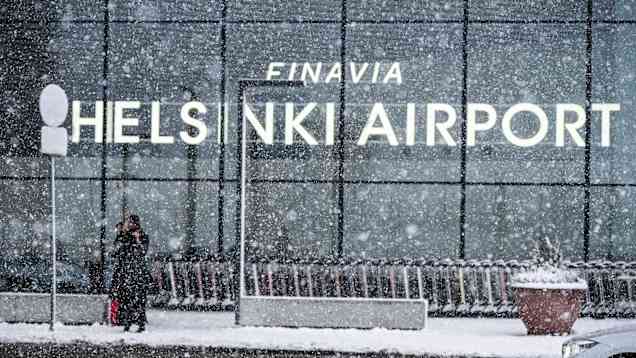 The Helsinki Airport sign shrouded in snow.