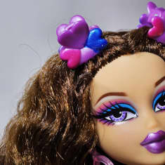 Lähikuva Bratz-nukesta, jolla on suuri pää, pitkät hiukset ja paljon meikkiä.
