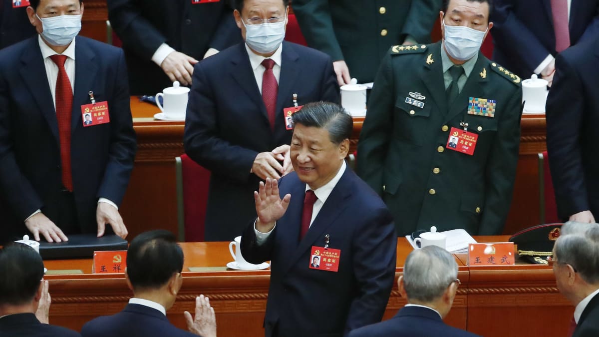 Xi Jinping vilkuttaa ympärillään seisoville kommunistipuolueen edustajille suuressa kansan salissa