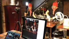 Kamera kuvaa kahta naista, jotka ohjaavat pikkujoulutapahtumaa verkossa. 