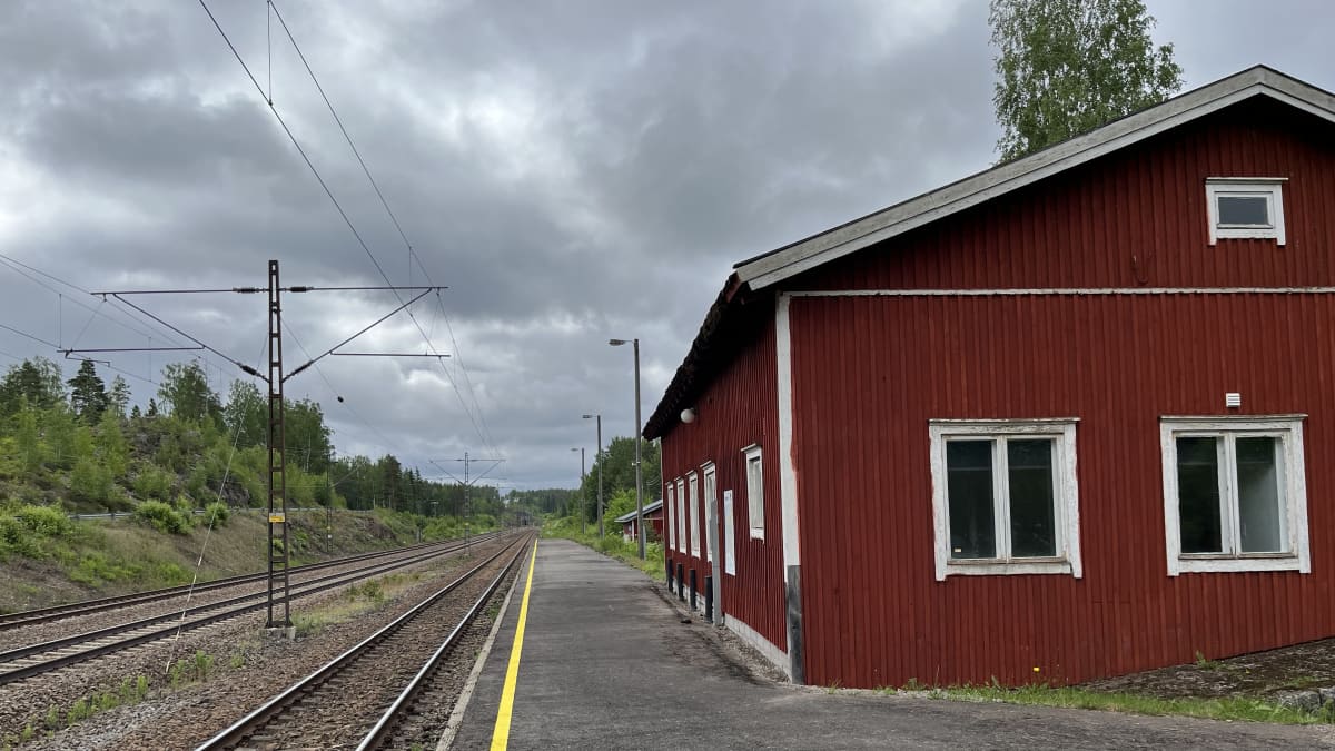 Juna-asema, jossa on punainen puinen asemarakennus.