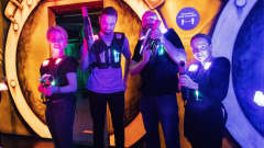 Megazone pelaajia värivaloliivit päällä ja aseet käsissään poseeraavat kameralle