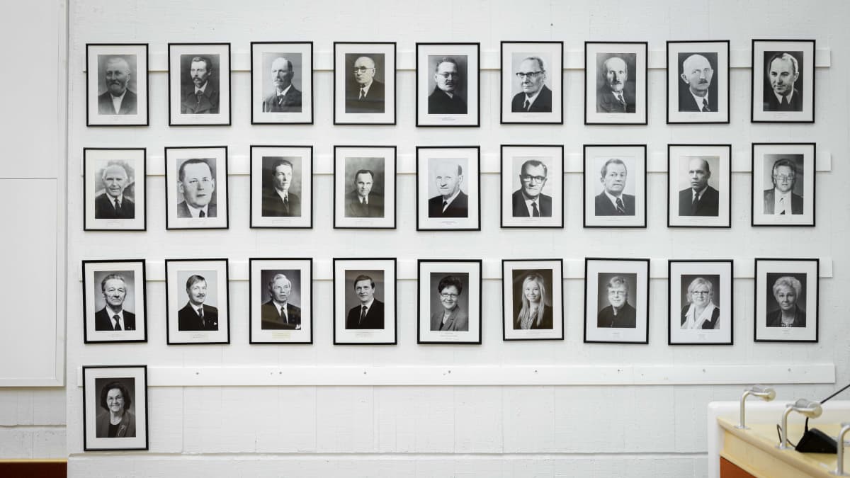 Kaupunginhallituksen puheenjohtajien valokuva Viitasaaren kunnantalon valtuustosalin seinällä.