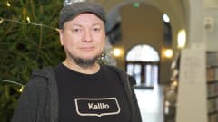 Janne Palander, kirjastovirkailja seisoo joulukuusen vieressä Kallion kirjastossa.