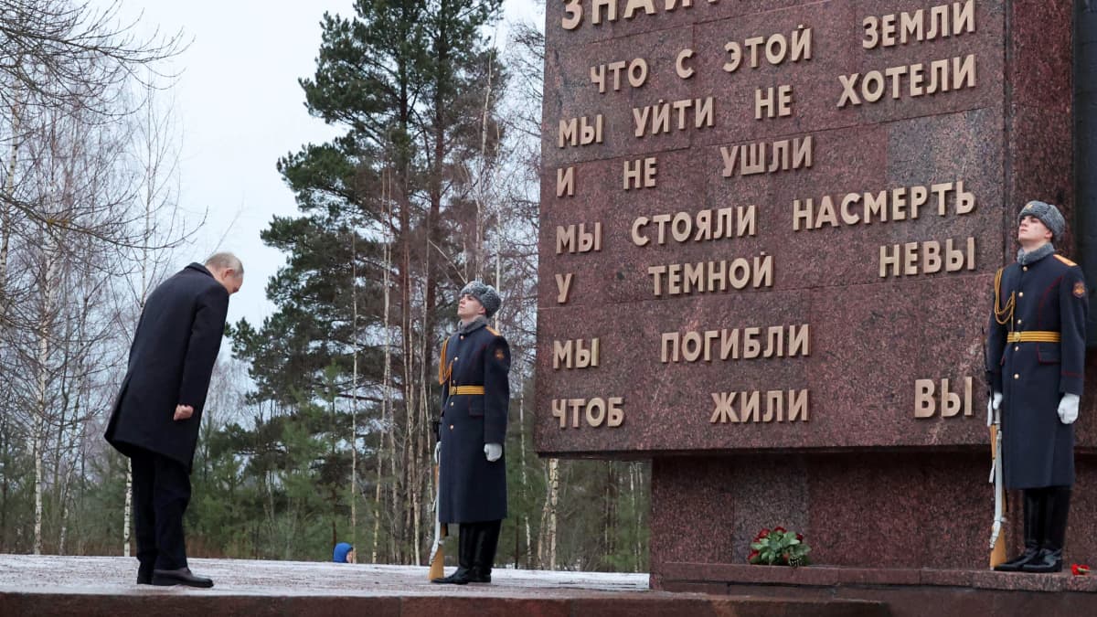 Vladimir Putin kumartaa muistomerkin edessä.