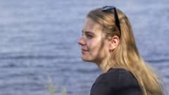 Ida Hulkko profiilikuvassa Näsijärven rannalla. Hänellä on aurinkolasit päälaella.