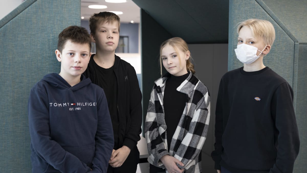 Koululaiset Uuuna Jouha, Juuso Mätasaho, Linnea Jansson ja Jaakko Ranta-Korpi seisovat koulun aulassa ja katsovat kameraan.