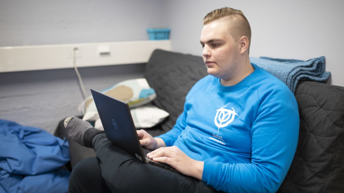 Turun ammattikorkeakoulun opiskelijakunnan hallituksen puheenjohtaja Matias Sillanmäki työskentelee tietokoneella sohvalla istuen.