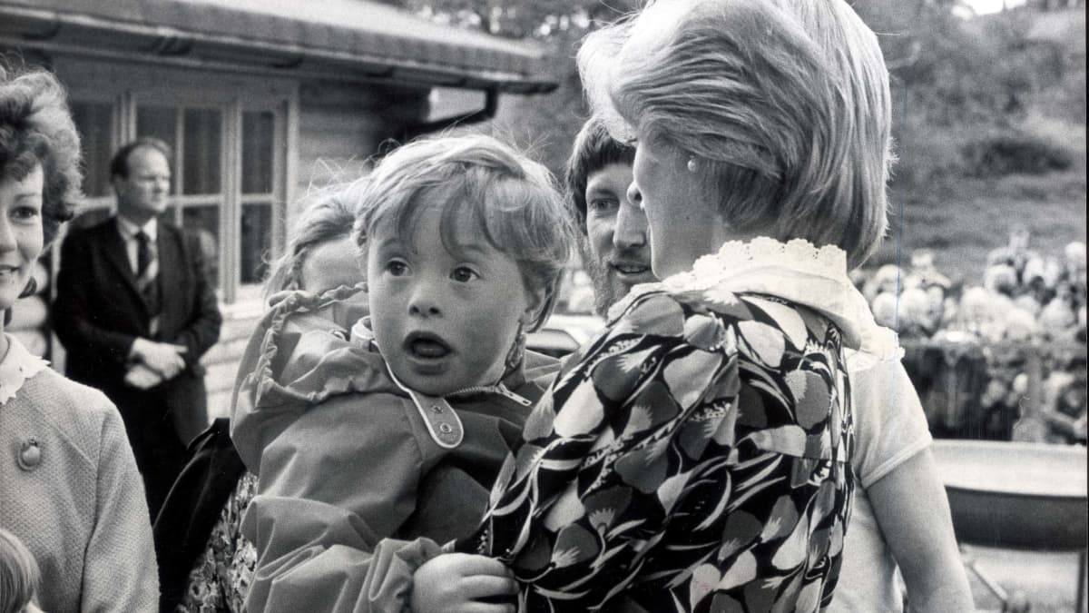 Diana kantaa sylissään kehitysvammaista pientä poikaa.