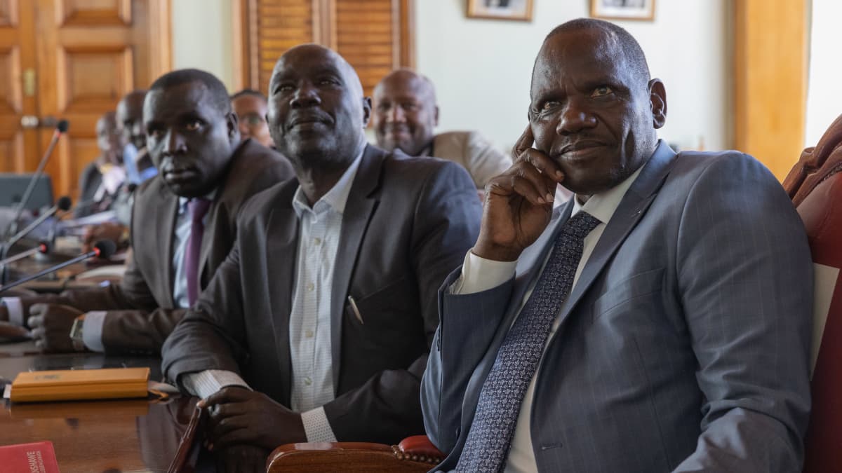 Kenialaiset kuvernöörit katsovat tyytyväisen näköisinä kokoushuoneessa videota Tampereella opiskelevista kenialaisista. 