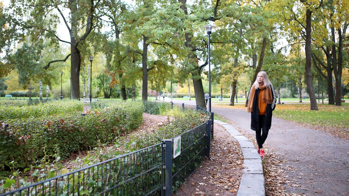 Salla-Maarit Karpio kävelee puistossa syksyllä.