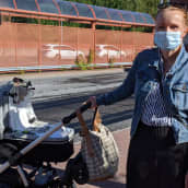 Katri Saukkonen lastenrattaiden kanssa ja maski naamalla.