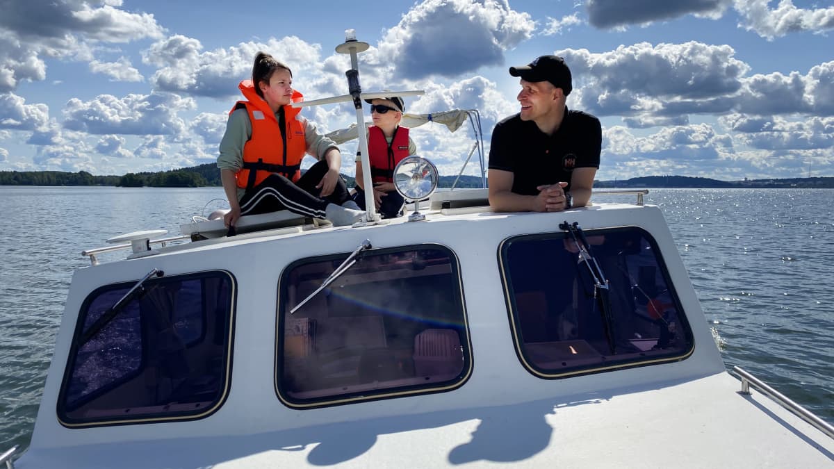 Tuomas Helen ja hänen lapset Sointu ja Petrus veneessä Lahden Vesijärvellä.