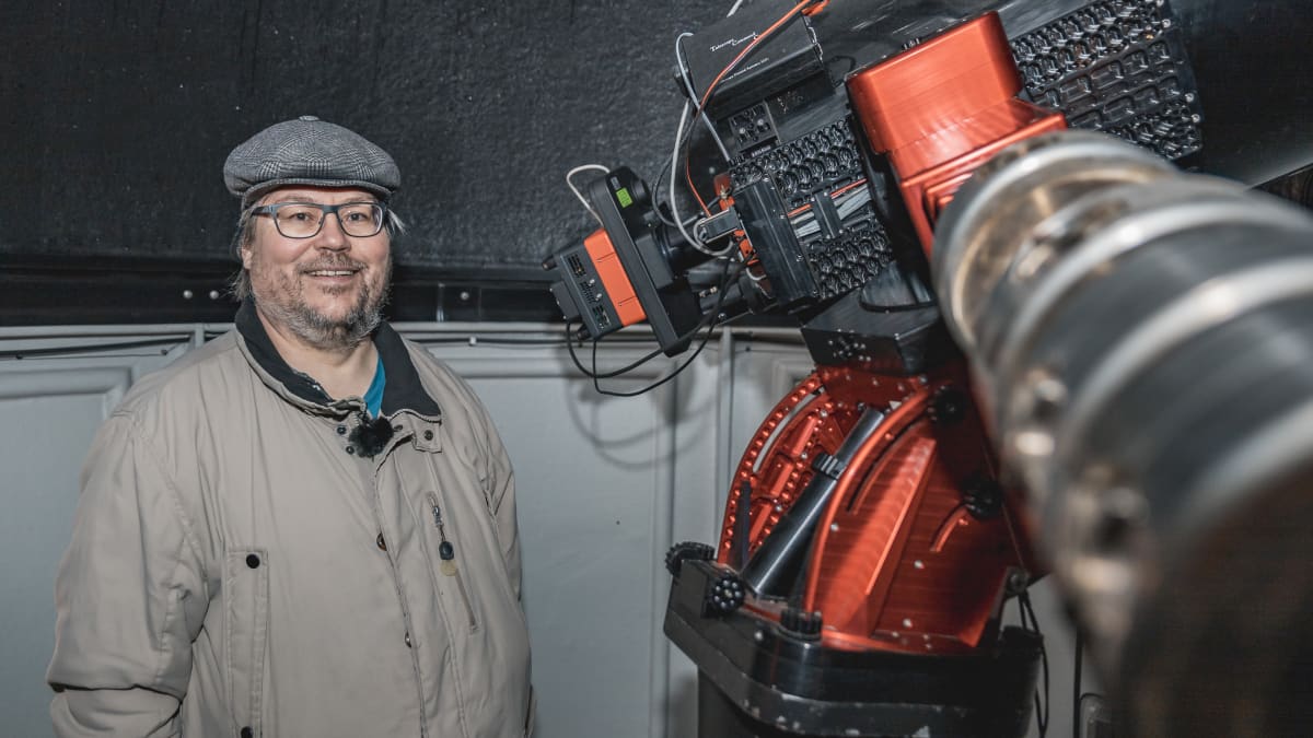 Tähtitieteen harrastaja Arto Oksanen seisoo peiliteleskoopin vierellä