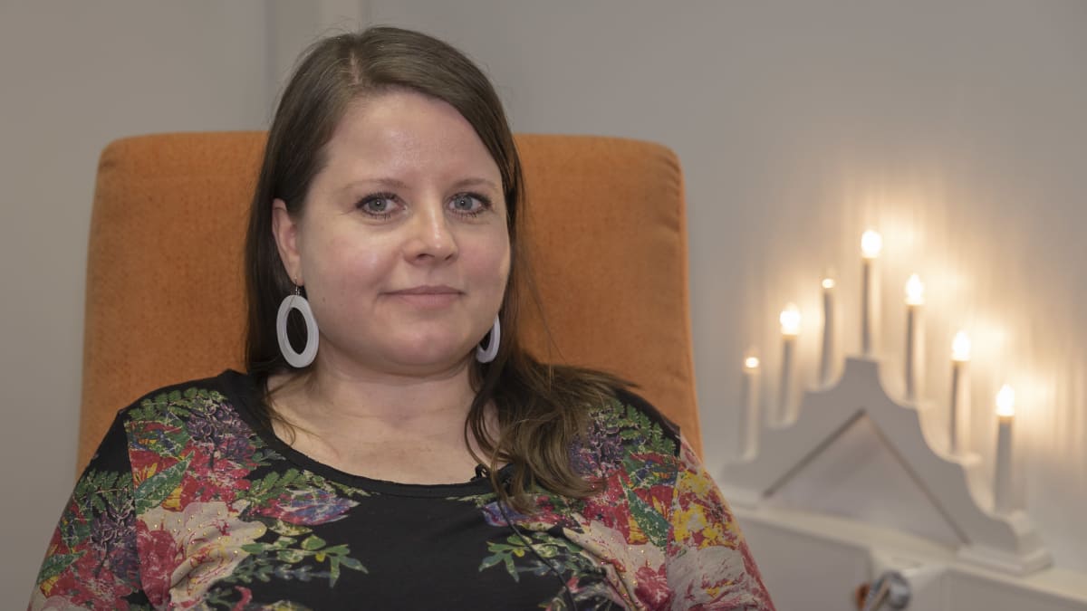 Maija-Leena Mattila. Sähköinen kynttelikkö loistaa taustalla. 