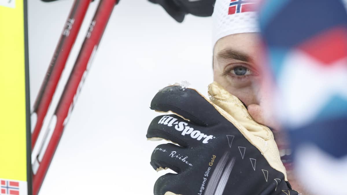 Jarl Magnus Riiber laittaa hanskan kasvojen eteen.