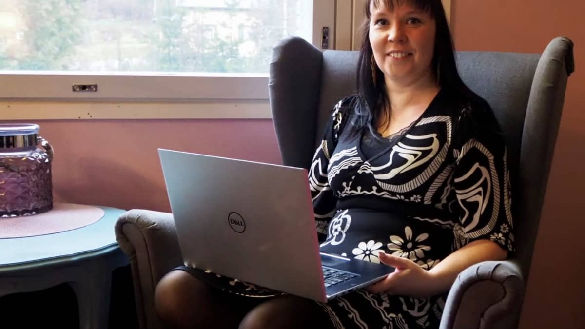 Seksuaaliterapeutti Susanna Syld istumassa nojatuolissa tietokone sylisään.