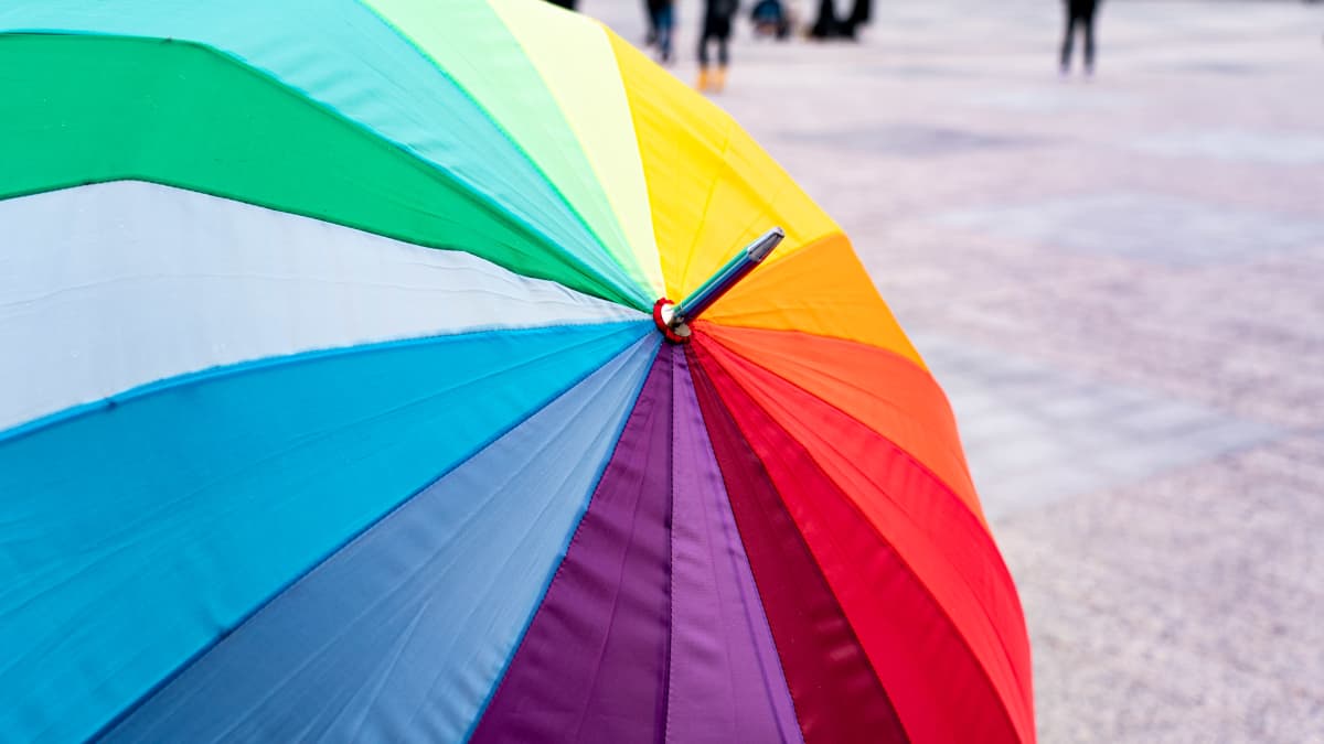 Sateenkaarilipun värinen sateenvarjo.
