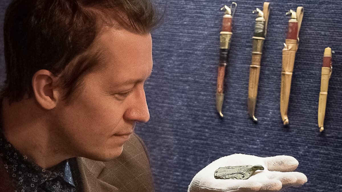 Arkeologi Janne Rantanen pitää kädellään Lappajärveltä löytynyttä arvokasta riipusta.