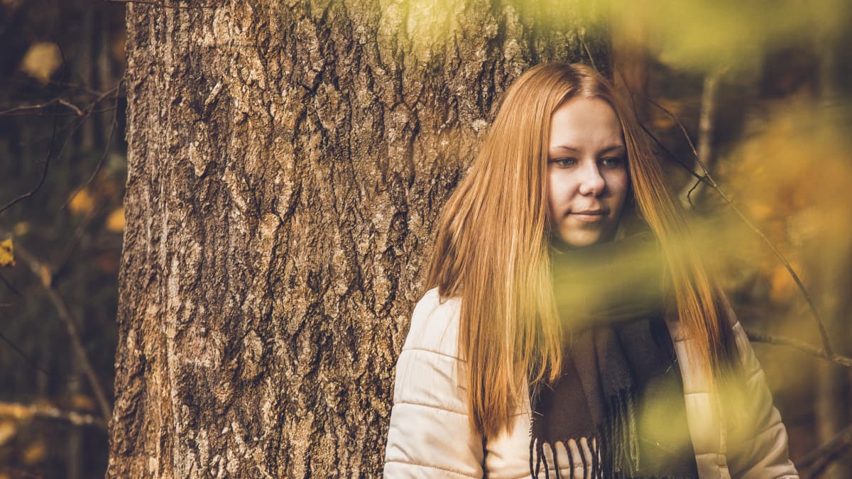 Nainen seisoo metsässä
