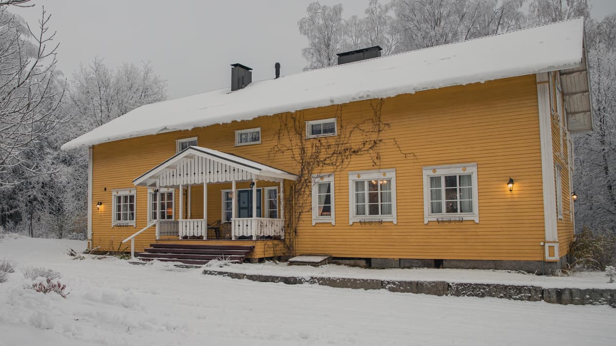 Keltainen kartano talvimaisemassa.