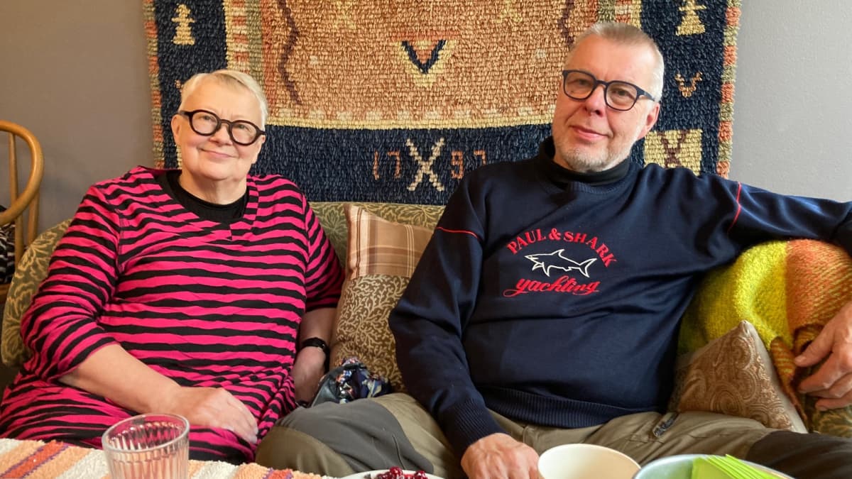 Annikki ja Erkki Enkola istuvat sohvalla Café Puustissa.