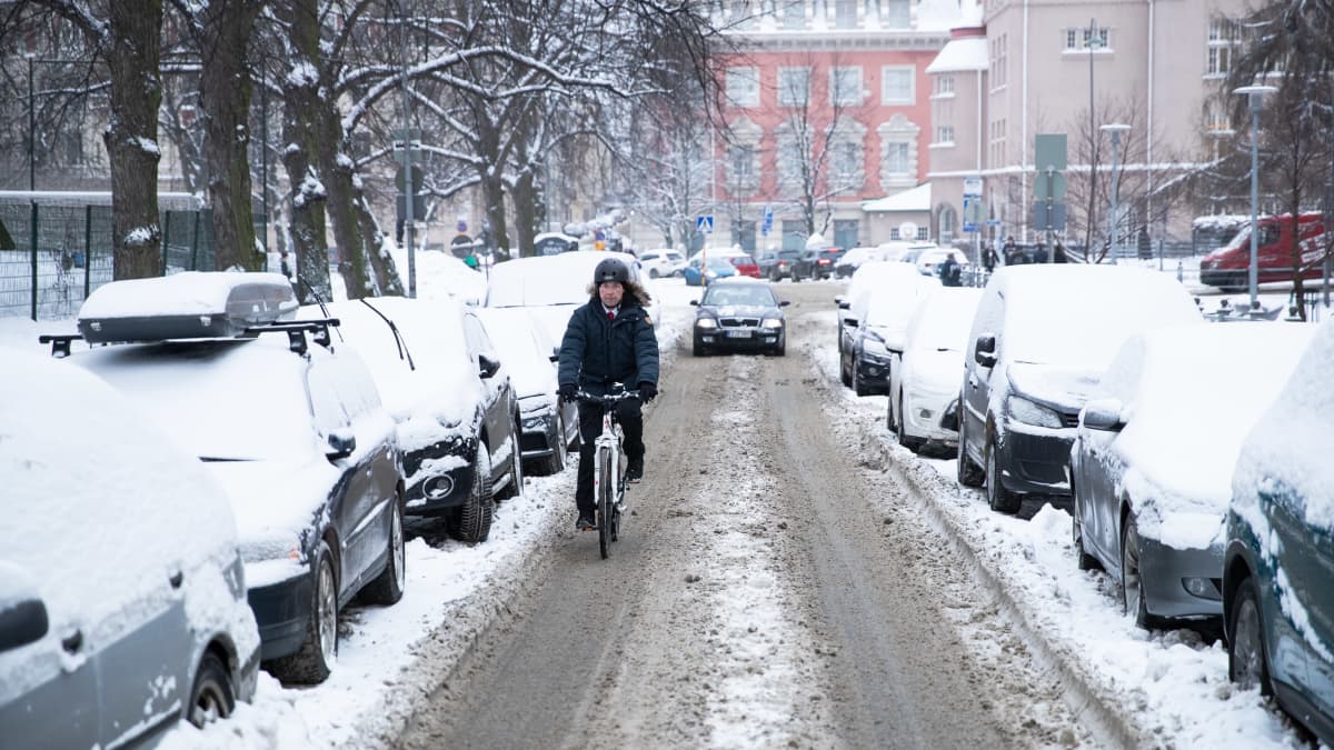 Jussi Halla-aho pyöräilee lumisella kadulla